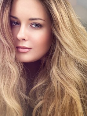 Güzel, gür saç stili, uzun, lüks saç ve güzellik makyajı olan, lüks moda ve doğal kozmetik fikri olan modern, sarışın bir kadın.