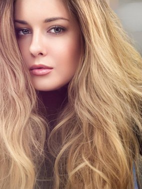 Güzel, gür saç stili, uzun, lüks saç ve güzellik makyajı olan, lüks moda ve doğal kozmetik fikri olan modern, sarışın bir kadın.