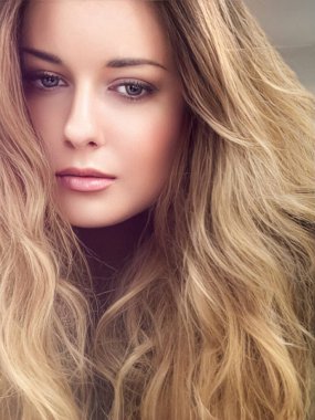 Güzel, gür saç stili, uzun, lüks saç ve güzellik makyajı olan, lüks moda ve doğal kozmetik fikri olan modern, sarışın bir kadın.