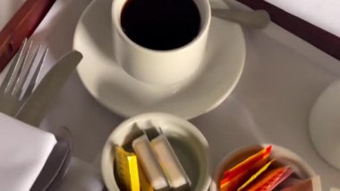 Mısır gevreği, kruvasan, bir bardak portakal suyu, kahve ve bir sürü reçel içeren geleneksel kıtasal kahvaltı seti, hepsi beyaz çarşaflı bir tepside güzelce sunuluyor. Yüksek kalite 4k görüntü