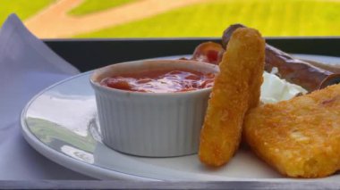 Patates kızartması, mantar, domates, sosis ve fırında fasulye içeren İngiliz kahvaltı tarifi, arka planda manzaralı kırsal bir manzara ile beyaz bir tabakta servis ediliyor. Yüksek kalite 4k görüntü