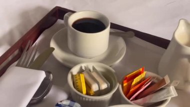 Mısır gevreği, kruvasan, bir bardak portakal suyu, kahve ve bir sürü reçel içeren geleneksel kıtasal kahvaltı seti, hepsi beyaz çarşaflı bir tepside güzelce sunuluyor. Yüksek kalite 4k görüntü