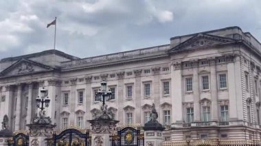 Karmaşık detaylar ve kraliyet amblemleriyle süslenmiş Buckingham Sarayı 'nın büyük cephesi Britanya' nın zengin monarşisinin ağır çekim sembolü olarak duruyor.