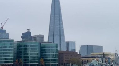 Çömlek, sisli ve yavaş çekimde çağdaş mimarinin parlak bir simgesi olan Londra 'daki modern cam ofis binalarının üzerinde yükseliyor.