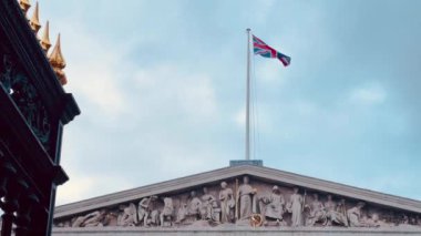 Büyük Londra binasının ön cephesi karışık oymalar ve heykellerle süslenmişti. Üstünde, rüzgarda dalgalanan İngiliz bayrağı vardı.