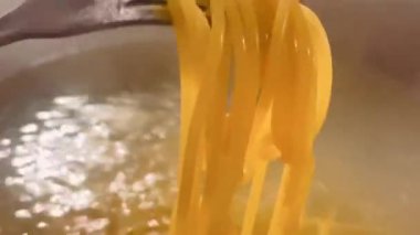 Kaynayan sudan taze pişmiş spagetti. Işıl ışıl ve mükemmel bir dente. Rahatlatıcı bir makarna tabağı yapmaya hazır.