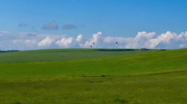 Eastbourne, Doğu Sussex, Birleşik Krallık 'ın manzaraları. Dağınık evler ağaçların arasında ve bulutlu bir gökyüzünün altındaki uzak tepelerin altında.
