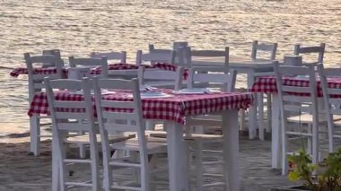 Deniz kenarındaki dört kişilik yemek masası sakin ve romantik deniz manzaralı bir yemek için mükemmel bir ortam sunuyor.