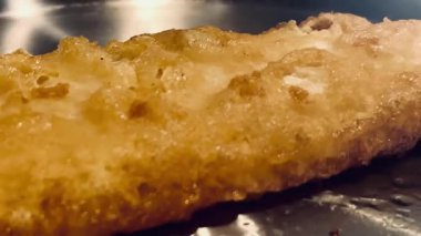 Kıtır kıtır altın renginde balık usulca cızırdar, geleneksel ve rahatlatıcı İngiliz yemeğinin özünü somutlaştırır, İngiliz balık ve patates kızartması.