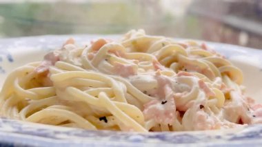 Narin somonlu kremalı spagetti. Klasik bir yemek için bol ve biberli sosla kaplanmış.