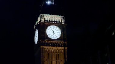 Büyük Ben, Londra, İngiltere 'de gece gökyüzüne karşı aydınlandı. Simgesel saati ışıl ışıl parlıyordu. Londonlar' ın tarihi cazibesini ve mimari ihtişamını ön plana çıkarıyordu.
