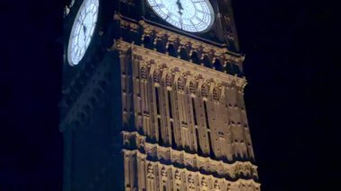 Büyük Ben, Londra, İngiltere 'de gece gökyüzüne karşı aydınlandı. Simgesel saati ışıl ışıl parlıyordu. Londonlar' ın tarihi cazibesini ve mimari ihtişamını ön plana çıkarıyordu.