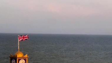 Eastbourne, Doğu Sussex, Birleşik Krallık, ikonik deniz kıyısı gökyüzünün altındaki sakin mavi denize doğru uzanan klasik İngiliz mimarisini gözler önüne seriyor ve yaşamla dolup taşıyor.