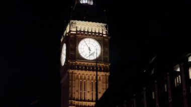 Büyük Ben, Londra, İngiltere 'de gece gökyüzüne karşı aydınlandı. Simgesel saati ışıl ışıl parlıyordu. Londonlar' ın tarihi cazibesini ve mimari ihtişamını ön plana çıkarıyordu.