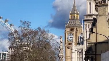 Büyük Ben, Londra Gözü ve Westminster Manastırı Londra 'nın merkezinde tarihi binalar ve çıplak kış ağaçları tarafından çerçevelenmiş parlak bir gökyüzünün altında.