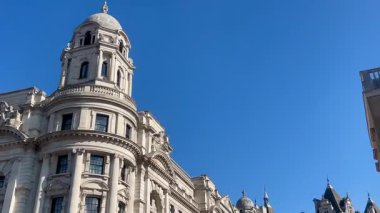 Londra 'nın merkezindeki zarif Barok tarzı hükümet binaları güneşli bir günde masmavi bir gökyüzünün altında parıldıyor.