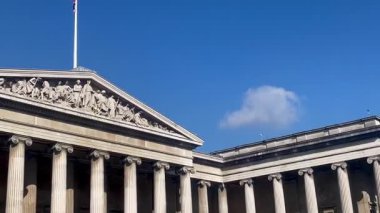 Güneşli bir günde Londra 'nın berrak gökyüzünün altında yükselen sütunlarıyla British Museum büyük neoklasik cephesi