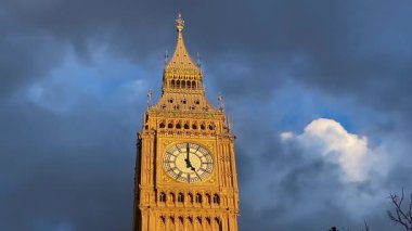 Londra, Westminster 'ın göbeğinde Büyük Ben alacakaranlıkta aydınlandı, dramatik bir gökyüzüne karşı altın parıltı