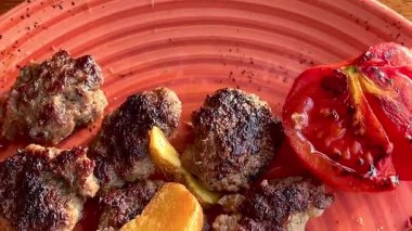 Kızarmış sebzeler, domatesler ve soğan ile pişirilmiş sulu biftek. Köy tabaklarında bol soslu, ağır çekimde..