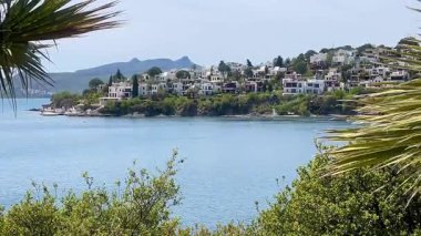 Beyazlatılmış villalar, Türkiye 'nin Bodrum kenti yakınlarındaki sakin Ege Denizi' nin üzerinde kayalık bir yarımadadan öteye yükselen dağlarla birlikte, ağır çekimde ilerliyorlar..