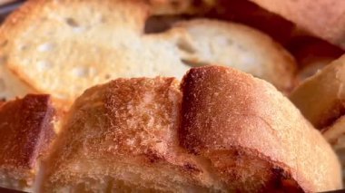 Taze kızarmış ekmeğin altın dilimleri gevrek kabuklu ve havadar kırıntılarıyla sıcak, yavaş çekimde servis edilir..