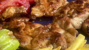 Kızarmış tavuk budu filetolarının yanında servis edilen altın cipsler, ağır çekimde.