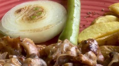 Canlı, mavi bir kasede servis edilen domates, soğan, marul ve limon dilimlerinden oluşan taze bir Akdeniz salatası..