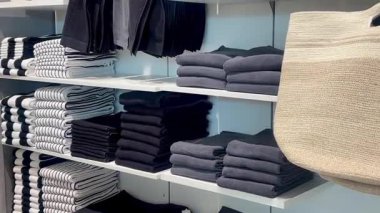 Sabun makineleri ve aksesuarlarla düzgünce dizilmiş havlular bir çarşaf dükkanında beyaz raflar, yavaş çekim.