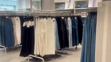 Butik elbise vitrinleri, ahşap askılar ve zarif tasarım, hızlı moda konsepti, yavaş çekim, ahşap raflarda desenli kadın modası sergileniyor.