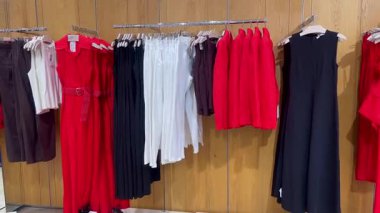 Butik elbise vitrinleri, ahşap askılar ve zarif tasarım, hızlı moda konsepti, yavaş çekim, ahşap raflarda desenli kadın modası sergileniyor.