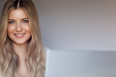 Laptop yaşam tarzı ve evden çalışma, internet kursu, bilgisayar kullanan uzun dalgalı saçlı sarışın kadın, doğal makyaj ve mavi gözler, dijital yaşam dengesi.