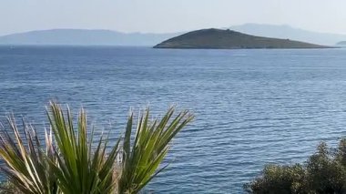 Türkiye 'nin Bodrum kenti yakınlarındaki Ege Denizi, ufuk boyunca uzanan adalar ve burunlar yemyeşil, yavaş çekim