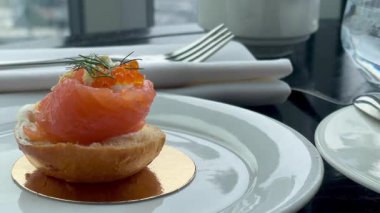 İşlenmiş bir sabah kahvaltısı füme somon kanapesi ve Londra 'da zengin sıcak çikolata, sessizce çatal bıçak, porselen ve ağır çekimde hazırlanmış.
