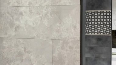 Dekoratif duvar fayanslarının bir görüntüsü nötr taşı kalın desenli, çağdaş ve geleneksel tasarımı harmanlayan, yavaş çekim ile birleştirir.