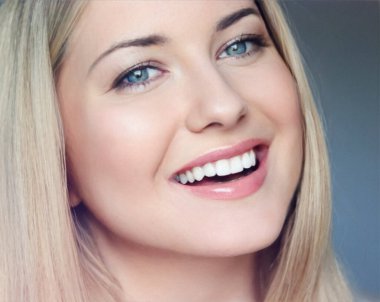 Doğal güzellik ve sağlıklı beyaz dişler, 30 'lu yaşlarında, gülümseyen sarışın bir kadının yakından çekilmiş portresi mavi gözlü, parlak tenli, gösterişli cilt bakımı ve yüz güzelliği.