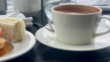 İşlenmiş bir sabah kahvaltısı füme somon kanapesi ve Londra 'da zengin sıcak çikolata, sessizce çatal bıçak, porselen ve ağır çekimde hazırlanmış.