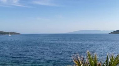 Türkiye 'nin Bodrum kenti yakınlarındaki Ege Denizi, ufuk boyunca uzanan adalar ve burunlar yemyeşil, yavaş çekim