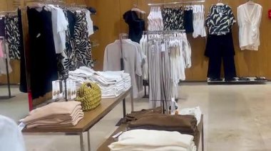 Butik elbise vitrinleri, ahşap askılar ve zarif tasarım, hızlı moda konsepti, yavaş çekim, ahşap raflarda desenli kadın modası sergileniyor.