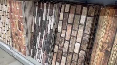 Tuğla ve taş desenleri bir dükkan rafını kaplıyor, kırsal dekorasyon seçenekleri sunuyor, yavaş çekim