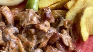 Canlı, mavi bir kasede servis edilen domates, soğan, marul ve limon dilimlerinden oluşan taze bir Akdeniz salatası..