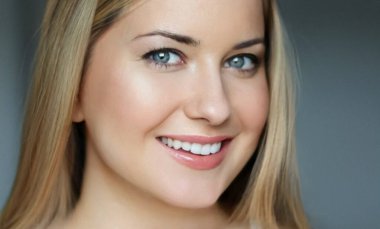 Doğal güzellik ve sağlıklı beyaz dişler, 30 'lu yaşlarında, gülümseyen sarışın bir kadının yakından çekilmiş portresi mavi gözlü, parlak tenli, gösterişli cilt bakımı ve yüz güzelliği.