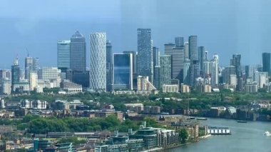 Kanarya Rıhtımı 'nın panoramik görüntüsü geometrik kuleler ve parıldayan cam cepheleriyle modern gökyüzü, Londra' nın göbeğinde gün ışığında, yavaş çekim