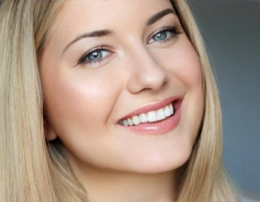 Doğal güzellik ve sağlıklı beyaz dişler, 30 'lu yaşlarında, gülümseyen sarışın bir kadının yakından çekilmiş portresi mavi gözlü, parlak tenli, gösterişli cilt bakımı ve yüz güzelliği.