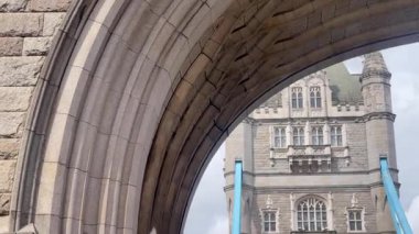Londra 'daki Tower Bridge' in görkemli bir yakın görüntüsü, Thames Nehri 'nin üzerinde dramatik bulutların altında cesurca duruyor, değerli bir İngiliz ikonu, yavaş çekim