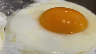 Tavada pırıl pırıl parlayan altın sarısı, kenarlarında hafif cızırdayan mükemmel kızarmış yumurta, klasik bir İngiliz kahvaltı anı.