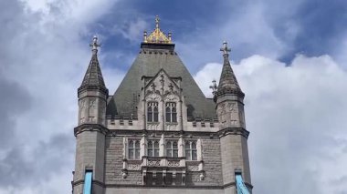 Londra 'daki Tower Bridge' in görkemli bir yakın görüntüsü, Thames Nehri 'nin üzerinde dramatik bulutların altında cesurca duruyor, değerli bir İngiliz ikonu, yavaş çekim