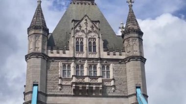 Londra 'daki Tower Bridge' in görkemli bir yakın görüntüsü, Thames Nehri 'nin üzerinde dramatik bulutların altında cesurca duruyor, değerli bir İngiliz ikonu, yavaş çekim