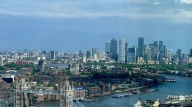 Londra 'nın modern nehir kenarı mimarisi ve Thames nehri boyunca gökdelenler, berrak mavi gökyüzü altında konut ve ticari binalar, yavaş çekim