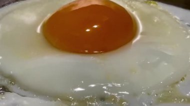 Tavada pırıl pırıl parlayan altın sarısı, kenarlarında hafif cızırdayan mükemmel kızarmış yumurta, klasik bir İngiliz kahvaltı anı.