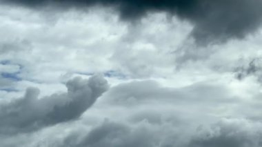 Bulutlu, dramatik gökyüzü yumuşak, katmanlı bulutlar ve mavi gökyüzü görünür, gün ışığında, yavaş çekimde yakalanır.